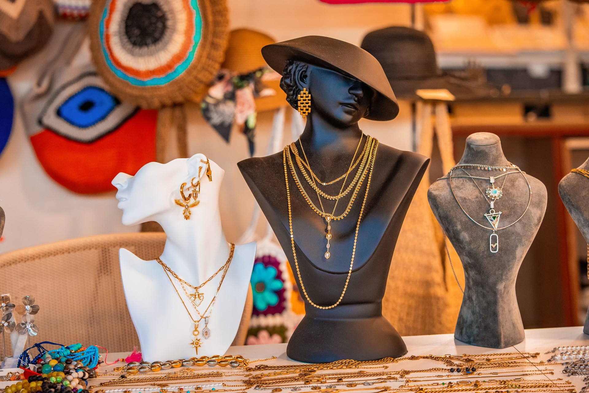 Mannequins elegantly displaying an array of golden necklaces and earrings inside a stylish jewelry store